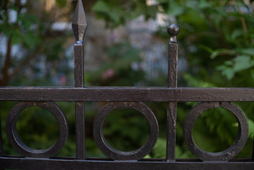 A part of a forged prick having a shape of 3 parts of a circle one cone and a peak against the background of greenery