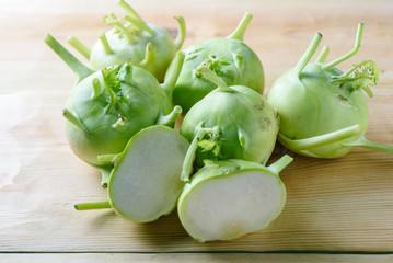 Fresh green kohlrabi on wood background. Kohlrabi or German turnip or turnip cabbage is a biennial vegetable, and is a low, stout cultivar of cabbage.