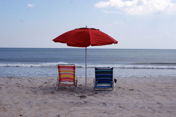 Beach chairs and umbrella on deserted beach