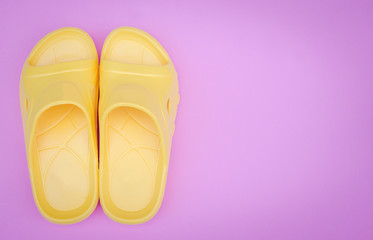 beautiful yellow sandal on pink pastel background with copy space..