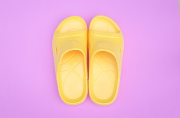 beautiful yellow sandal on pink pastel background with copy space..
