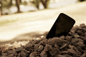 Broken cellphone abandoned and lost among the gravel