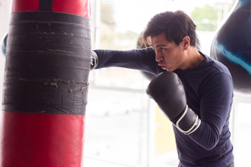hombre entrenando con guantes sacos de entrenamiento en gimnasio entrenador