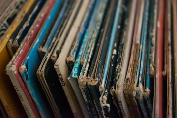 A colorful collection of  antique vinyl records in cases stacked up against each other. Antique...