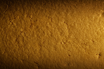 Color yellow background of dirty porous material. Illuminated by a narrow strip of light, with shadows on the edges of the image.