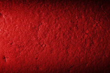 Color red background of dirty porous material. Illuminated by a narrow strip of light, with shadows on the edges of the image.