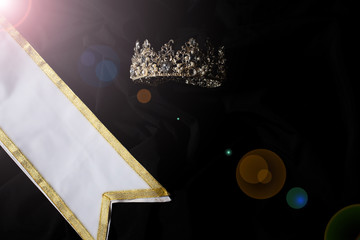White Gold Winner Sash for Miss Pageant Beauty Contest, empty area for text winner country word, studio lighting abstract dark drapping textile background, Importance Decoration with Diamond Crown