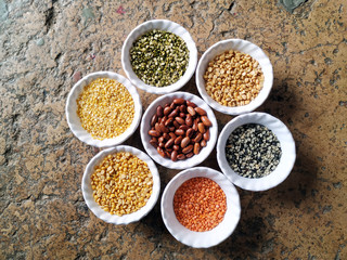 Uncooked pulses,grains and seeds in White bowls over stone background. selective focus