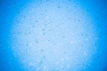 Rain droplets on blue glass background, Water drops on glass.