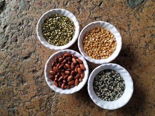 Uncooked pulses,grains and seeds in White bowls over stone background. selective focus