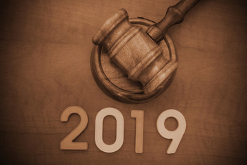 Concept of new laws and changes in court system. Wooden judge gavel and numbers 2019