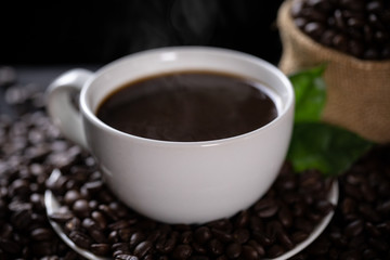 Hot coffee cup with coffee beans on the wooden table