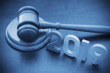 Concept of new laws and court. Wooden judge gavel and numbers 2019 on table