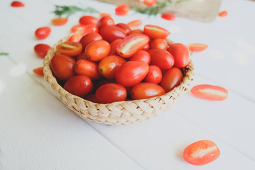 Fresh tomatoes and rosemary on a white background.