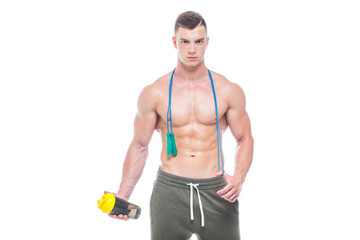 Muscular man skipping rope. Portrait of muscular young man with jumping rope drinking water with...