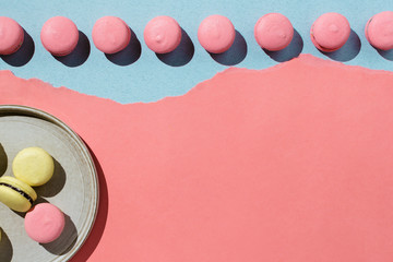 Flatlay of yellow and pink vegan macaroons on pastel background