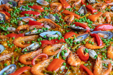 Spanish seafood paella in fry pan with mussels, shrimps and vegetables. Seafood paella background, closeup, traditional spanish rice dish