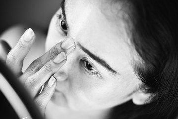 Obraz premium Asian woman applying cosmetics makeup and using color correction concealer, Learning doing self makeup.