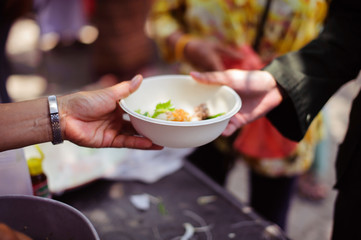 The concept of sharing help : Participation in sharing food for the poor : The Concept of Love : The beggar is waiting for food from charity aid