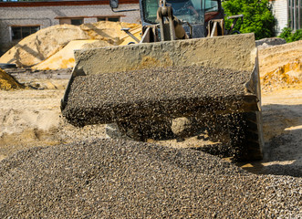  tractor collects scoop with  gravel. excavator extracts sand and gravel for  concrete mix.