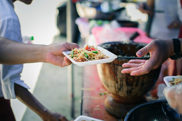 volunteers giving food to poor people in desperate need : The concept of food sharing Help solve Hunger for the homeless