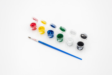 Colorful paints and brushes quietly placed on a white background