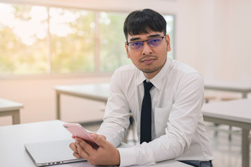 Young business man working at office with laptop, mobile and documents