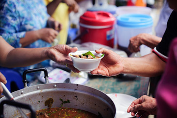 Poor people receiving food from donations : Homeless people are helped with food relief, famine...