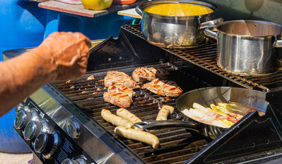 Meat, sausage, vegetables on a gas grill