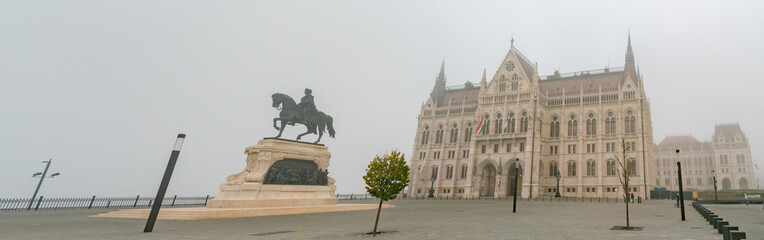 Fototapeta premium Foggy view of the Hungarian Parliament Building in a haze morning
