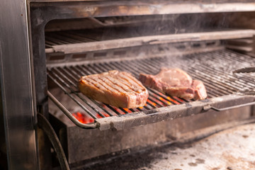 food, craft and delicious concept - cooking steak on a grill
