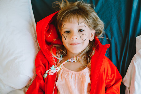 Portrait of little girl with painted hearts on her face