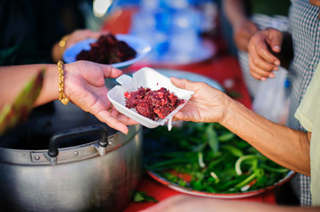 Homeless people pick up charity food from the food donors in society : The concept of the beggar problem on earth : The Hand of the Beggars receives charity food from fellow human beings
