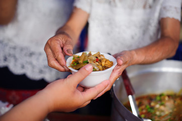 Homeless people pick up charity food from the food donors in society : The concept of the beggar problem on earth : The Hand of the Beggars receives charity food from fellow human beings
