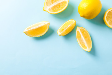 Flat lay composition with lemons on color background, space for text