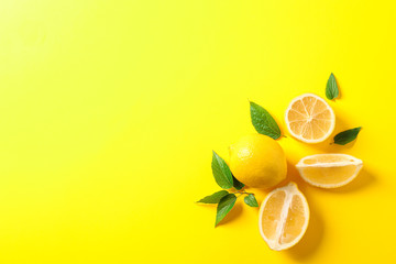 Flat lay composition with lemons on color background, space for text