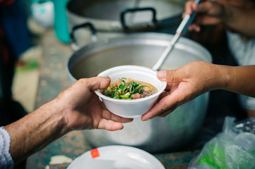 Concept homelessness : Food needs of the poor in society Help with Food Donation : Homeless people pick up charity food from the food donors in society : The concept of the beggar problem on earth