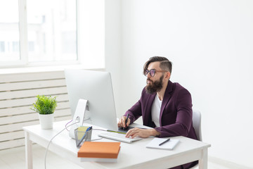 People and technology concept - Attractive man with beard, dressed in purple jacket working on at...