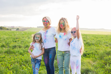 Fototapeta premium Holiday, summer and fun concept - Group of people dancing in field at holi festival