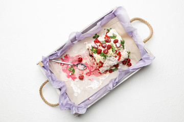 Tray with a delicious meringue cake with ripe fruit on a white background. Top view