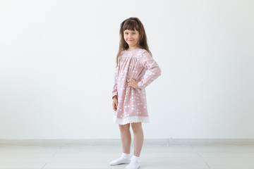 model, clothing designer, people concept - little girl model in pink dress over the white background