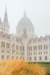 Fototapeta na wymiar Foggy view of the Hungarian Parliament Building in a haze morning