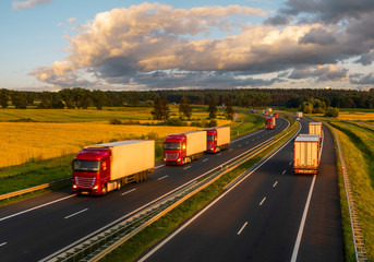 Fototapeta na wymiar intensive highway traffic at sunset - column of trucks on the motorway in Poland