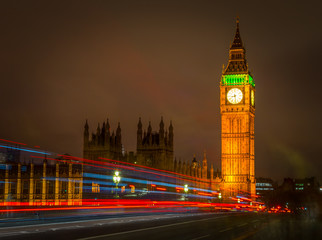 Fototapeta na wymiar Big Ben Houses of Parliament Westminster Palace gothic architecture and Light trail from double decker bus passing on Westminster Bridge, London, England