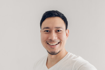 Happy man is taking selfie of himself and present the empty copy space background.