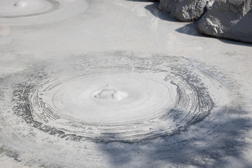 Fototapeta na wymiar closeup of gray mud boiling bubble hell hot springs at Japan.
