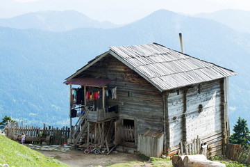 An authentic old wooden house in a highland village amid endless mountain ranges