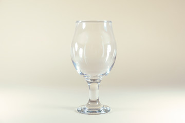 A clear wine glass is standing on a white background