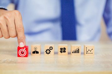 Hand of busines hold a target with arrow,stacking wooden blocks into steps,Concept of business growth success