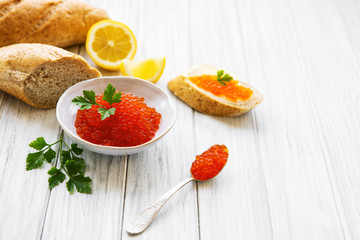 Red caviar in bowl and sandwiches